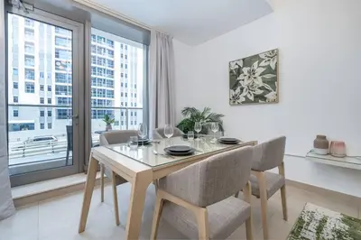 a dining room with a table and chairs and a large window at Lush Tropical Getaway in Dubai Marina in Dubai
