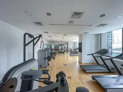 a gym with treadmills and elliptical machines at Lush Tropical Getaway in Dubai Marina in Dubai