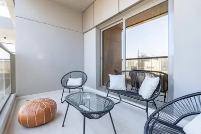 a balcony with chairs and tables and a large window at Romantic hideaway w breathtaking Burj Khalifa view in Dubai