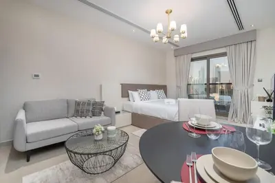 a living room with a couch and a bed and a table at Romantic hideaway w breathtaking Burj Khalifa view in Dubai