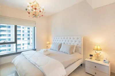 a bedroom with a white bed and a large window at Downtown Dubai, Luxury 2 Bed 2 Bath Apartment - Pool, Gym, AirCon, Parking - Views of The Dubai Fountain & Burj Khalifa in Dubai
