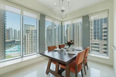 a dining room with a table and chairs and large windows at Downtown Dubai, Luxury 2 Bed 2 Bath Apartment - Pool, Gym, AirCon, Parking - Views of The Dubai Fountain & Burj Khalifa in Dubai