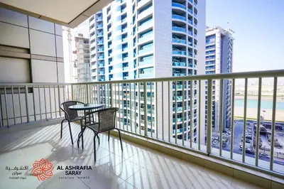 a balcony with two chairs and a table on it at Alashrafia Saray - Wonderful 1BR in Sports City in Dubai