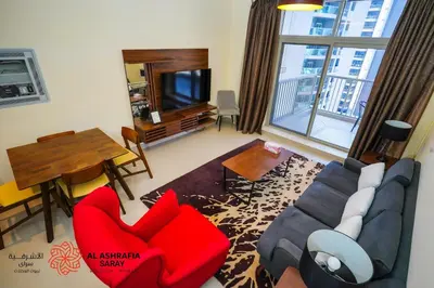 a living room with a couch and a table at Alashrafia Saray - Wonderful 1BR in Sports City in Dubai