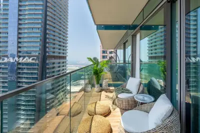 a balcony with chairs and tables on a building at GuestReady - Luxury 1BR | Skyline & Canal View in Dubai