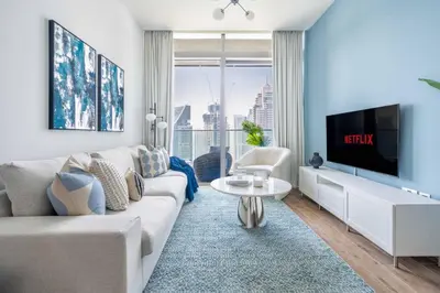 a living room with a couch and a tv at GuestReady - Luxury 1BR | Skyline & Canal View in Dubai