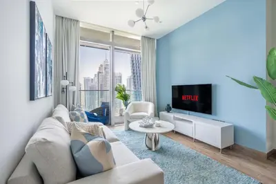 a living room with a couch and a tv at GuestReady - Luxury 1BR | Skyline & Canal View in Dubai