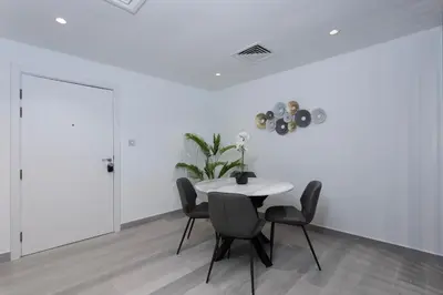 a white dining room with a white table and chairs at Modern Brand New 1BR Holiday Homes at Greens in Dubai