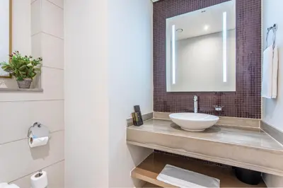 a bathroom with a sink and a mirror at Damac Towers By Paramount Apartments - The S Holiday Homes in Dubai
