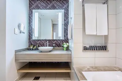 a bathroom with a sink and a mirror at Damac Towers By Paramount Apartments - The S Holiday Homes in Dubai
