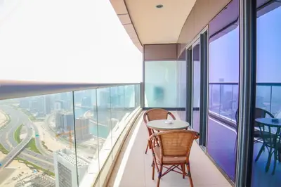 a balcony with a table and chairs in a building at Damac Towers By Paramount Apartments - The S Holiday Homes in Dubai