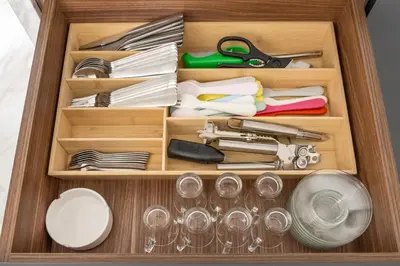 a wooden drawer filled with dishes and utensils at Stunning 1BR in Bahar near JBR Beach in Dubai