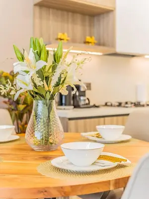 a wooden table with a vase of flowers on it at Charming Condo With Balcony Near Dubai Hills Park in Dubai