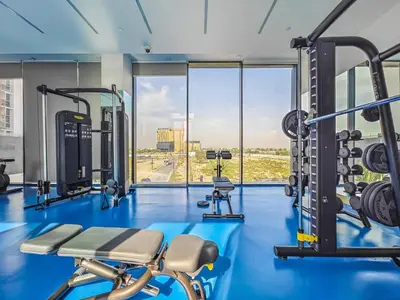 a gym with blue flooring and a large window at Charming Condo With Balcony Near Dubai Hills Park in Dubai