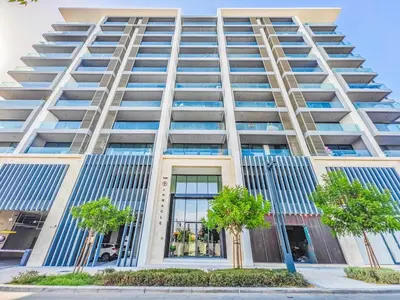 a tall building with trees in front of it at Charming Condo With Balcony Near Dubai Hills Park in Dubai