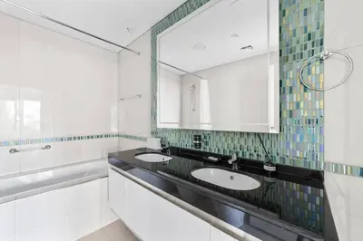 a bathroom with two sinks and a large mirror at StoneTree - DAMAC Heights 1 BR - Amazing Facilities in Dubai