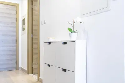 a kitchen with white cabinets and a white wall at Marina & Downtown Views in Modern Studio - JVC in Dubai