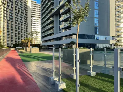 a tree in front of a tall building at Marina & Downtown Views in Modern Studio - JVC in Dubai