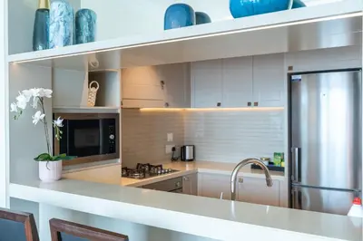 a kitchen with white cabinets and a stainless steel refrigerator at New Listing - Serviced Apartment & TOP Amenities in Dubai