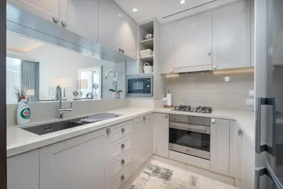 a kitchen with white cabinets and a sink at New Listing - Serviced Apartment & TOP Amenities in Dubai