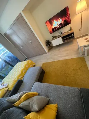a living room with a couch and a tv at Modern Studio Center of Dubai in Dubai